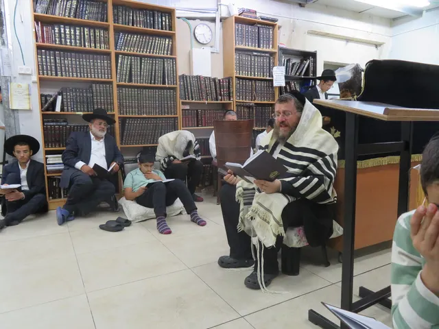 בני הקהילה יושבים על הרצפה וקוראים קינות בתשעה באב